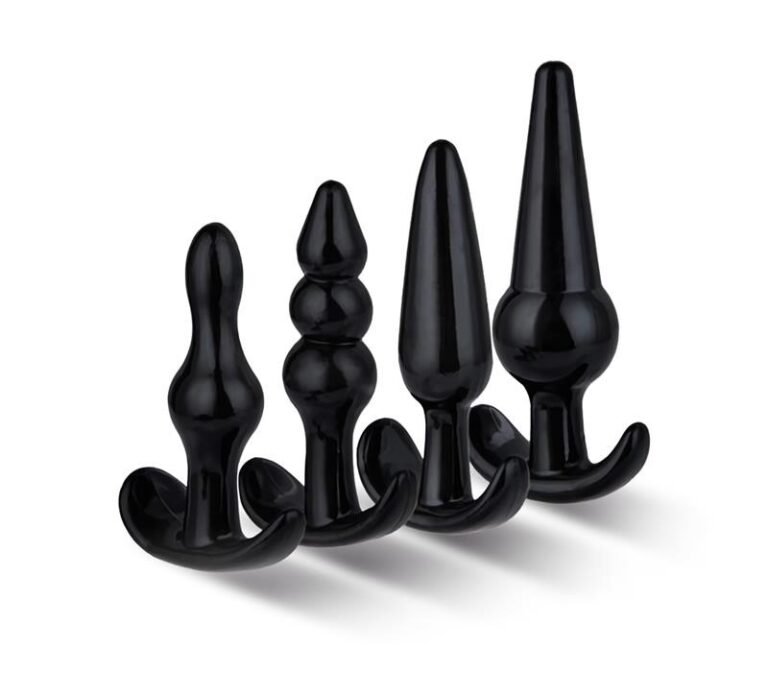 Set de cuatro plugs anales de silicona negra con diferentes formas y base de ancla, presentados sobre fondo blanco.